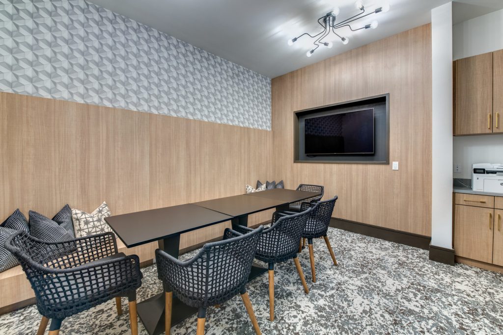 Conference meeting room with lounge and table seating, and television for presentations