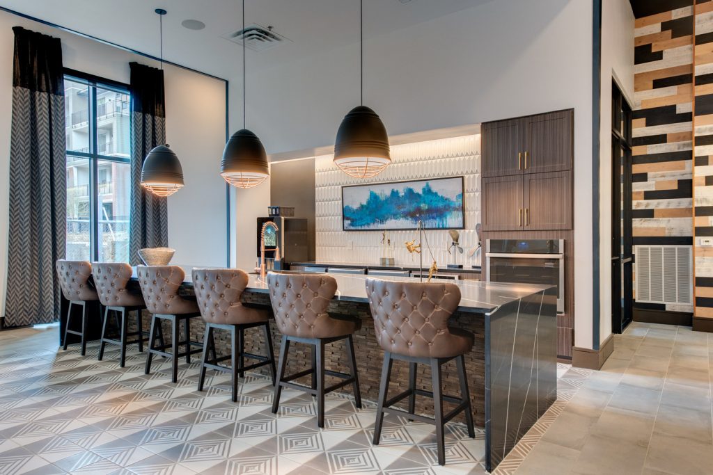 Clubhouse kitchen with stainless steel appliances, single sink, island, and bar seating